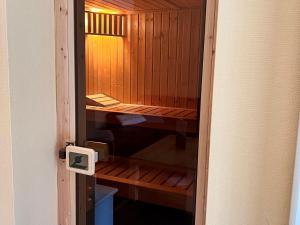 a small wooden sauna with a lightswitch on a door at Ferienhaus Müritzzeit in Röbel an der Müritz in Marienfelde