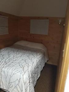 Un dormitorio con una cama blanca en una habitación. en Living Waters Guest Cottage Motel, Kincardine Guest Resort, en Kincardine