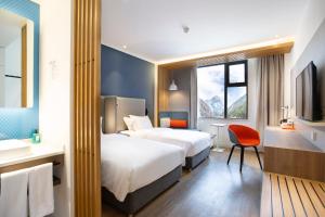 una camera d'albergo con due letti e un bagno di Holiday Inn Express Jiuzhaigou, an IHG Hotel a Valle del Jiuzhaigou