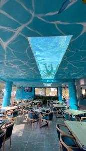 a restaurant with tables and chairs and a blue ceiling at Ilio Boutique Hotel in Ksamil