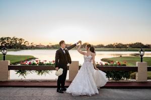 a bride and groom posing for a picture in front of a pond at Mission Resort and Club in Howey in the Hills