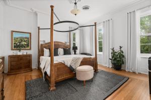 a bedroom with a canopy bed and a rug at The CAPE in Picton