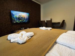 a hotel room with towels on a bed at Borisz Apartman in Makó