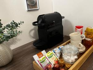 a coffee maker sitting on a table with food at Borisz Apartman in Makó
