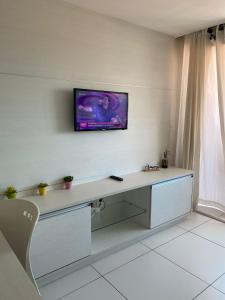 um quarto com uma secretária e uma televisão na parede em Flat na Orla de Tambaú em João Pessoa