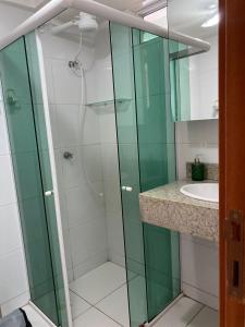 uma casa de banho com uma cabina de duche em vidro e um lavatório. em Flat na Orla de Tambaú em João Pessoa