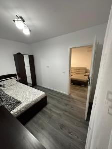a bedroom with a bed and a room with a couch at Apartament Anastasia Residence in Oradea