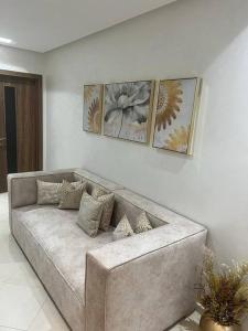 - un canapé dans un salon avec trois photos sur le mur dans l'établissement Appartement Ferdaous, à Agadir