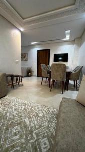 Cette chambre comprend un salon avec une table et des chaises. dans l'établissement Appartement Ferdaous, à Agadir