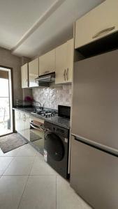 Il comprend une cuisine équipée d'une cuisinière et d'un réfrigérateur. dans l'établissement Appartement Ferdaous, à Agadir