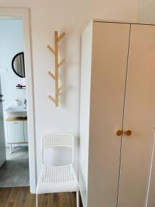 a small room with a white chair and a closet at Daro tiny house in Vama Veche
