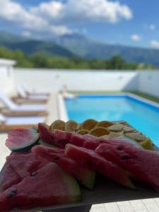 einen Haufen Obst auf einem Tisch neben einem Pool in der Unterkunft Vila Nur Mostar in Mostar