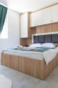 a large bed with a wooden frame in a bedroom at Vila Nur Mostar in Mostar