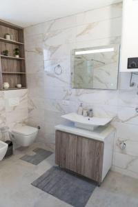 a bathroom with a sink and a toilet and a mirror at Vila Nur Mostar in Mostar