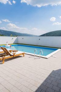 a swimming pool with a table and a bench next to it at Vila Nur Mostar in Mostar
