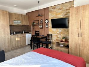 a bedroom with a bed and a kitchen with a table at Nana S44 Milmari Spa&Wellness in Kopaonik