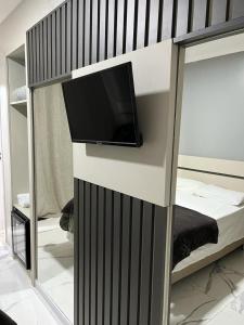 a bedroom with a bunk bed with a flat screen tv at HOTEL BARLOS ADUANA in Uruguaiana