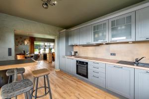 a kitchen with white cabinets and a table and chairs at Einzigartige Traumwohnung mit Whirlpool & Sauna bietet Luxus und Erholung in Neuheilenbach