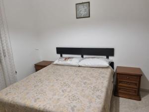 ein Schlafzimmer mit einem Bett mit zwei Nachttischen und einer Uhr in der Unterkunft Casa Relax Cupello in Cupello