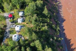 an overhead view of a group of campgrounds next to a river at Gravity Luxury Domes in South Maitland