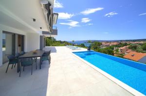 a villa with a swimming pool and a table and chairs at Unique Apartment with private pool in Krk
