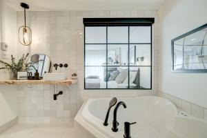 a white bathroom with a tub and a window at Les Lofts du Lac des Sables by Gestion ELITE in Sainte-Agathe-des-Monts +129 photos