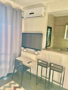 a room with a table and two chairs and a tv at Ravena 016 in Ribeirão Preto