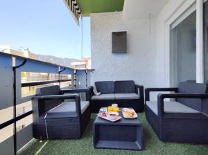 balkon z krzesłami i stołem z tacą z jedzeniem w obiekcie La Mar de Venus - Luxury Views in Puerto Deportivo w Marbelli
