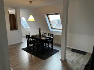 een eetkamer met een tafel en stoelen en een raam bij A&V Apartments Schöne Dachgeschoss Wohnung in Gelsenkirchen