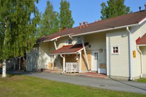 une maison blanche avec un toit marron dans l'établissement Apartment Vuokatin Taika 2, à Vuokatti