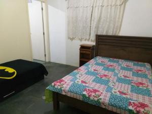 a bedroom with a bed with a quilt on it at Chacara Vale dos Sonhos Itu in Itu