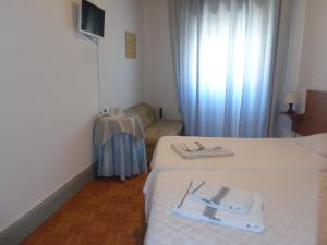 una habitación de hotel con dos camas y un sofá en Portuense Alojamento Local, en Oporto