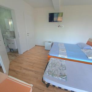 mały pokój z 2 łóżkami i telewizorem w obiekcie Villa Bardha w mieście Struga