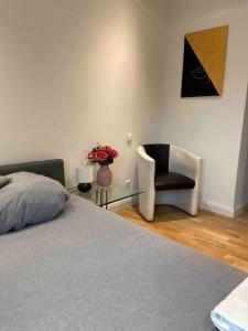 um quarto com uma cama e uma cadeira e um vaso de flores em Luxury apartment with air conditioning & Jaccuzzi near Frankfurt Wiesbaden em Hofheim