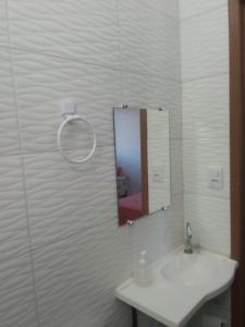 a bathroom with a white sink and a mirror at POUSADA ROSA DOS LENÇÓIS in Barreirinhas