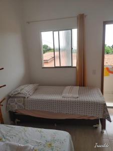 een slaapkamer met 2 bedden en een raam bij POUSADA ROSA DOS LENÇÓIS in Barreirinhas