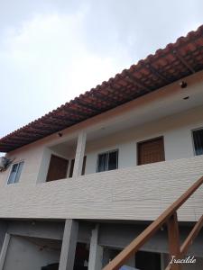 una casa con balcón en la parte superior en POUSADA ROSA DOS LENÇÓIS, en Barreirinhas