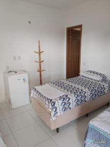 a bedroom with a bed and a refrigerator at POUSADA ROSA DOS LENÇÓIS in Barreirinhas