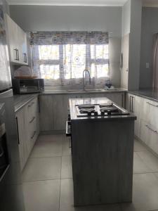 a kitchen with a sink and a stove in it at Emabheni Self Catering in Langstrand