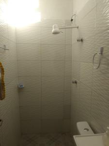 een badkamer met een glazen douche en een toilet bij POUSADA ROSA DOS LENÇÓIS in Barreirinhas