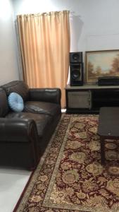 sala de estar con sofá de cuero y alfombra en Emabheni Self Catering en Langstrand