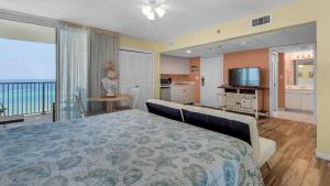 a bedroom with a bed and a kitchen with a balcony at Long Beach Tower 1 800E in Panama City Beach
