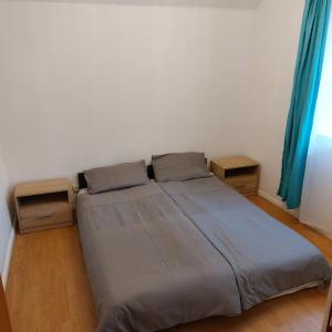 uma cama num quarto com duas mesas de cabeceira em Szary domek 1 em Wieprz