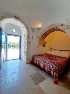 a bedroom with a bed and an open door at Trullo Tranquillo Ostuni in Ostuni
