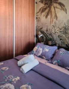fioletowe łóżko z dwoma ręcznikami na górze w obiekcie Appart'Eden : vue panoramique sur Saint-Denis w mieście Sainte-Clotilde