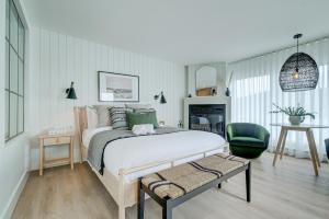 a bedroom with a large bed and a green chair at Les Lofts du Lac des Sables by KASANIA in Sainte-Agathe-des-Monts
