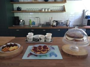 una mesa con dos platos de comida y un pastel en Vineyard Barns Gower, en Swansea