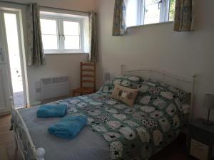 Un dormitorio con una cama con almohadas azules. en Vineyard Barns Gower, en Swansea