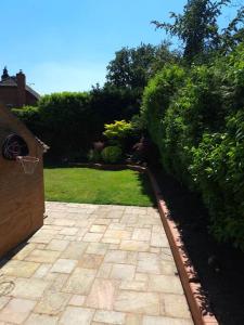 a garden with a brick walkway with a basketball hoop at The Lookout in Bromsgrove