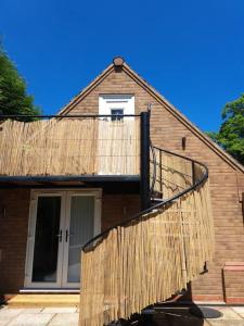 uma casa com uma rampa de madeira que leva até uma varanda em The Lookout em Bromsgrove